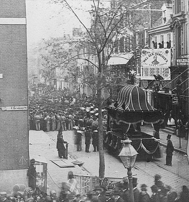 1865. Abraham Lincoln temetési menete Springfieldben. A koporsót szállító lóvontatású járműv sínen haladt végig a város utcáin..jpg