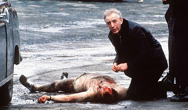 1988. Tegnapi nap hunyt el Alec Reid lelkész. A képen 1988-ban egy felrobbantott brit katonának adja fel az utolsó kenetet Észak-Írországban..jpg